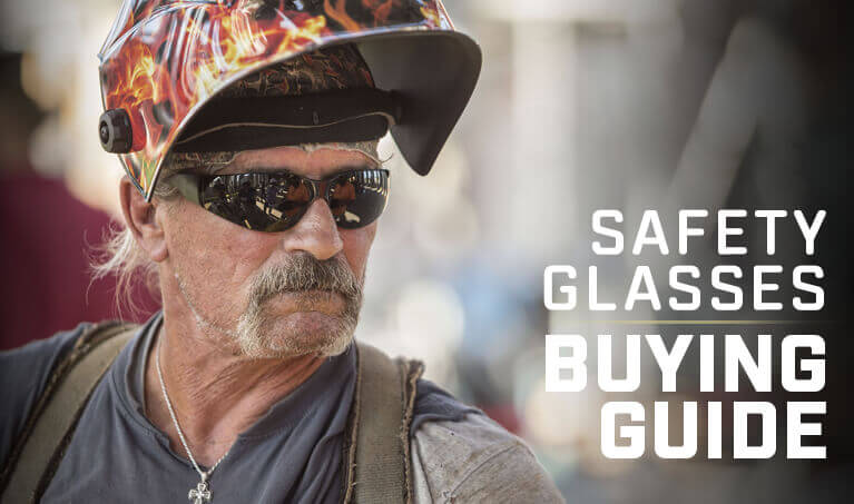 Welder wearing a welding helmet and safety glasses