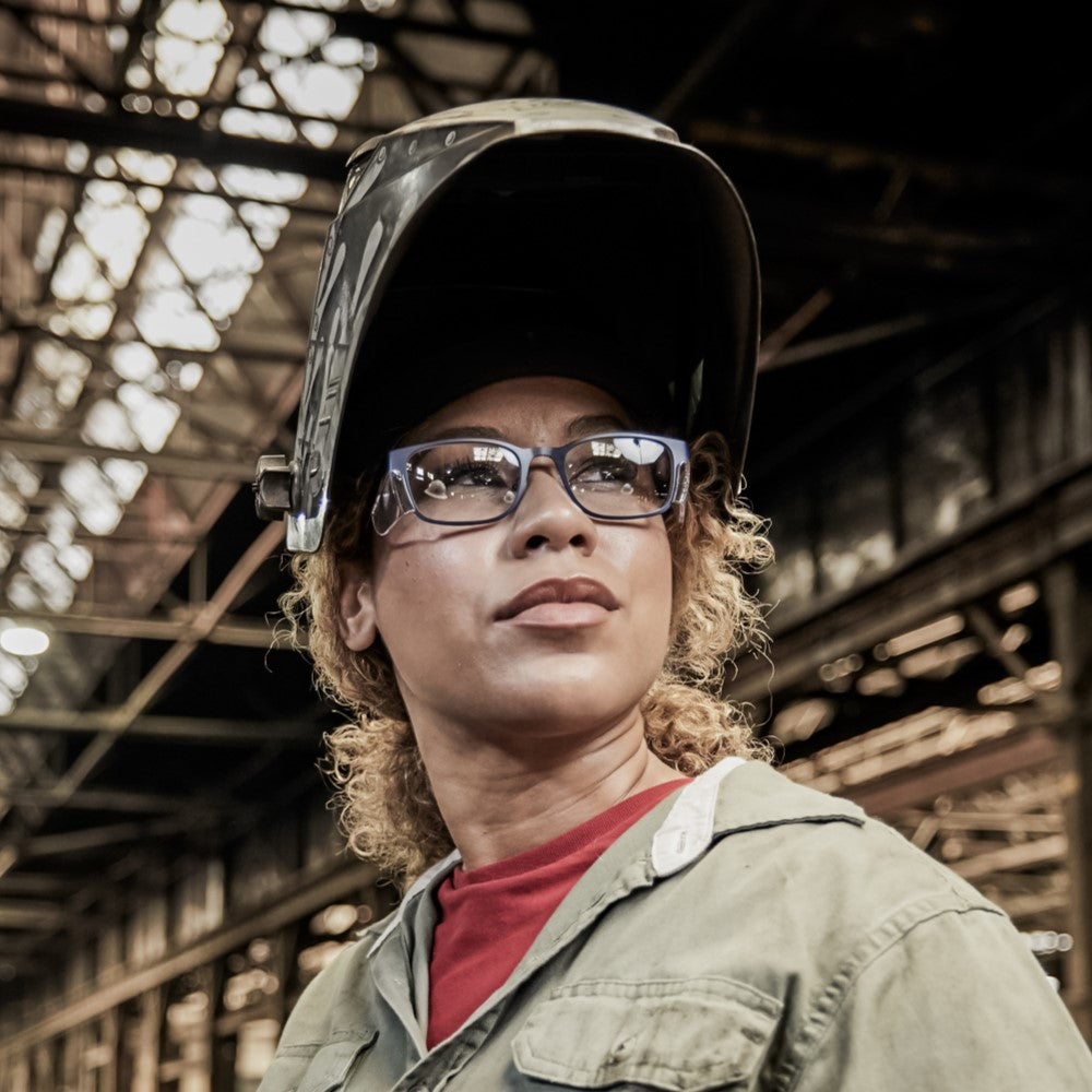 Woman wearing Wiley X Harmony Worksight blue prescription safety glasses with clear side shields and a welding helmet.