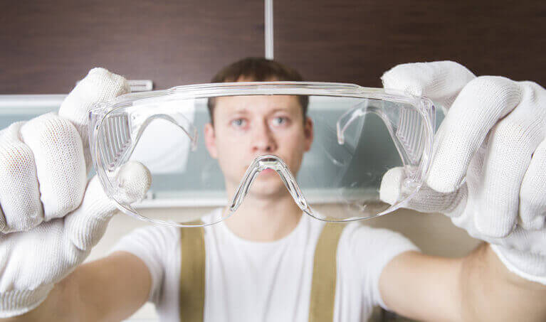 Worker inspecting their safety glasses